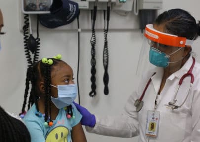 Photo of a young girl talking to a doctor.